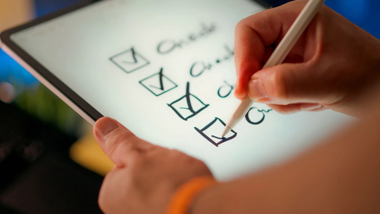 Hände bedienen ein Tablet neben einer Checkliste auf Papier.